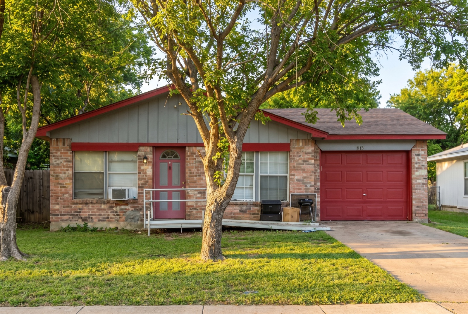 Single-story ranch home with grey siding and red trim in east Fort Worth, Texas
